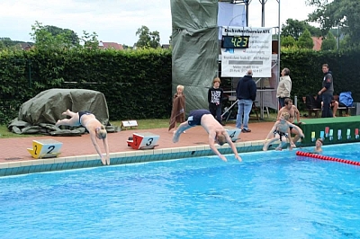 Menschen springen ins Wasser eines Schwimmbeckens